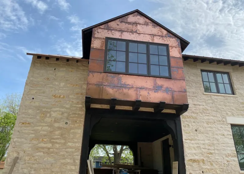 Copper metal panel facade on a stone building for Roof Repair in Lake Ridge